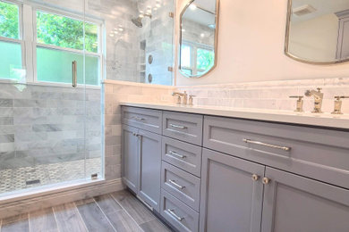 Inspiration for a large transitional master gray tile and marble tile porcelain tile, brown floor and double-sink double shower remodel in Chicago with recessed-panel cabinets, gray cabinets, gray walls, an undermount sink, quartz countertops, a hinged shower door, white countertops, a niche and a built-in vanity