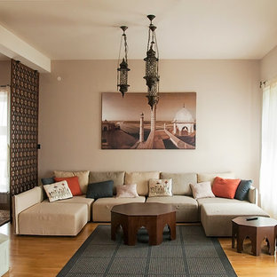 Modelo de salón para visitas abierto, mediterráneo, sin televisor, con paredes beige, suelo de madera clara y estufa de leña