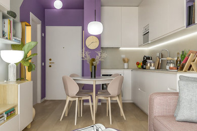 This is an example of a small contemporary l-shaped open plan kitchen in Milan with a single-bowl sink, flat-panel cabinets, white cabinets, engineered stone countertops, beige splashback, engineered quartz splashback, stainless steel appliances, vinyl flooring and beige worktops.