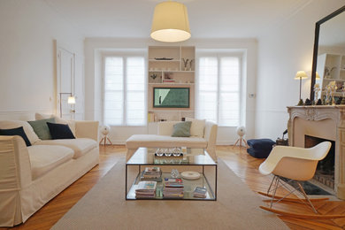 Cette image montre un salon traditionnel de taille moyenne et ouvert avec un mur blanc, parquet clair, une cheminée standard, un manteau de cheminée en pierre, aucun téléviseur et un sol marron.