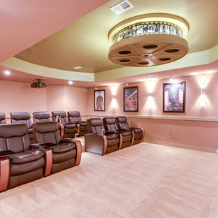 Cette photo montre une salle de cinéma chic fermée avec un mur orange, moquette, un écran de projection et un sol orange.