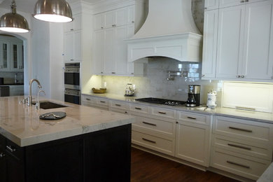 Eat-in kitchen - large eclectic l-shaped medium tone wood floor eat-in kitchen idea in Austin with an undermount sink, recessed-panel cabinets, white cabinets, quartzite countertops, white backsplash, stone tile backsplash and paneled appliances