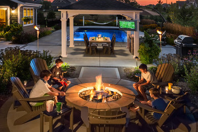 Design ideas for a mid-sized traditional backyard patio in Milwaukee with a fire feature, concrete slab and a gazebo/cabana.