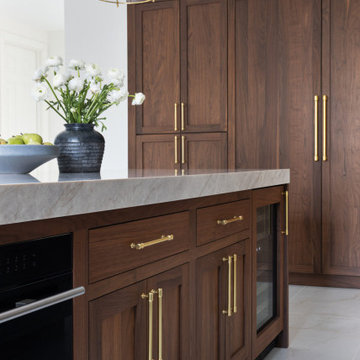 Custom Walnut and White Kitchen Remodel with Marble Slab Backsplash and Brass Ac