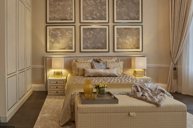 This is an example of a large traditional master bedroom in London with beige walls and dark hardwood floors.