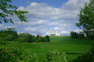 Large country white three-story wood gable roof idea in Montreal