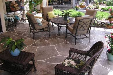Photo of a mid-sized mediterranean backyard patio in St Louis with stamped concrete and a roof extension.
