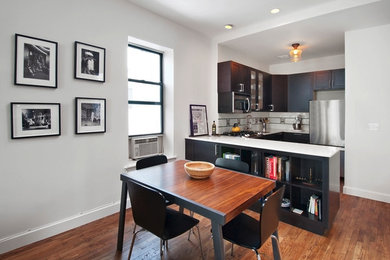 Inspiration for a small contemporary u-shaped medium tone wood floor eat-in kitchen remodel in New York with a drop-in sink, shaker cabinets, dark wood cabinets, quartzite countertops, white backsplash, ceramic backsplash, stainless steel appliances and a peninsula
