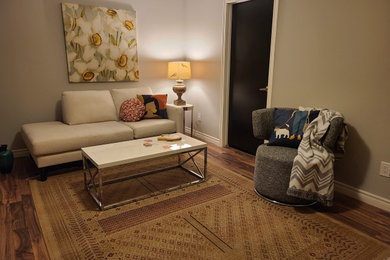 Ejemplo de sala de juegos en casa moderna de tamaño medio con paredes grises, suelo laminado, televisor independiente y suelo marrón