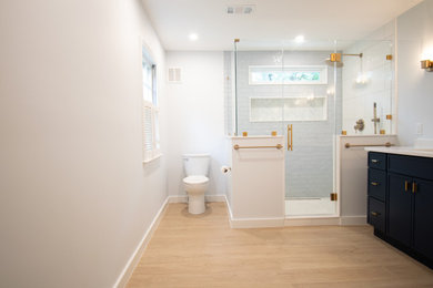 Example of a large transitional master multicolored tile and glass tile cement tile floor, multicolored floor and double-sink corner shower design in Baltimore with shaker cabinets, blue cabinets, a two-piece toilet, white walls, an undermount sink, quartz countertops, a hinged shower door, white countertops, a niche and a built-in vanity