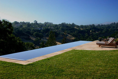 Design ideas for a large traditional backyard rectangular infinity pool in San Francisco with natural stone pavers.