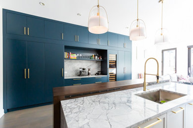 Foto de cocina contemporánea con armarios con paneles lisos, puertas de armario azules, una isla, suelo marrón, encimeras multicolor y encimera de cuarcita