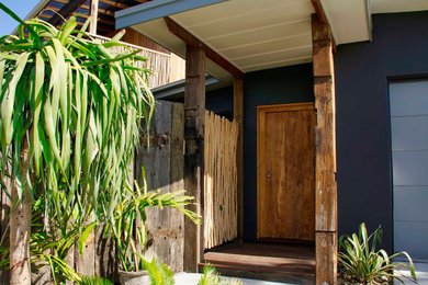 Design ideas for a tropical entryway in Other with purple walls, a medium wood front door and wood walls.