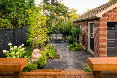 This is an example of a mid-sized eclectic partial sun backyard concrete paver landscaping in Toronto.