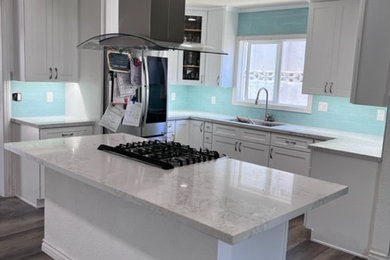 Small minimalist vinyl floor and brown floor eat-in kitchen photo in Other with a single-bowl sink, shaker cabinets, white cabinets, quartz countertops, blue backsplash, porcelain backsplash, stainless steel appliances, an island and gray countertops