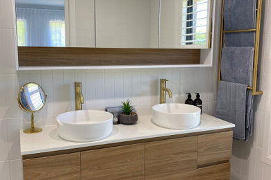 Inspiration for a mid-sized modern master bathroom in Melbourne with light wood cabinets, an open shower, a one-piece toilet, white tile, ceramic tile, white walls, ceramic floors, a vessel sink, engineered quartz benchtops, multi-coloured floor, an open shower, multi-coloured benchtops, a double vanity and a floating vanity.