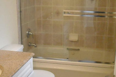 Tub/shower combo - large beige tile tub/shower combo idea in San Francisco with recessed-panel cabinets, white cabinets and granite countertops