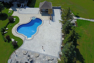 Photo of a large traditional backyard stone landscaping in Toronto.