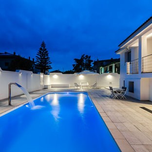 Idéer för en modern pool längs med huset, med en fontän och naturstensplattor