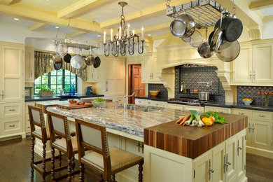 Example of a classic kitchen design in Boston with a double-bowl sink, shaker cabinets, yellow cabinets, gray backsplash and an island