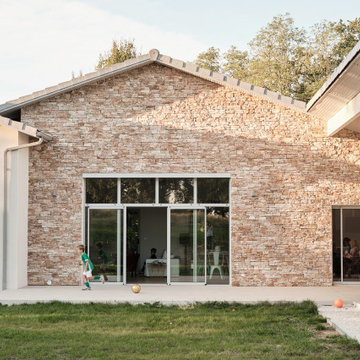 Maison contemporaine, décrochés de façades, parement pierres et menuiseries RAL7