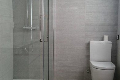 Medium sized modern shower room bathroom in Other with a built-in shower, a one-piece toilet, grey tiles, ceramic tiles, grey walls and ceramic flooring.