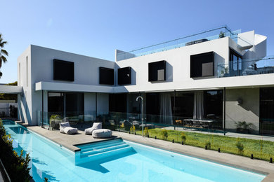 Photo of an expansive contemporary backyard l-shaped pool in Melbourne with with a pool and concrete pavers.