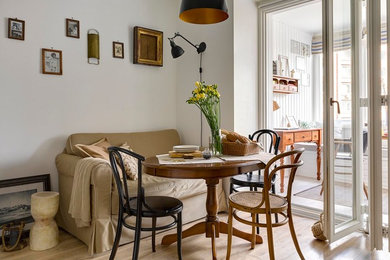 Scandinavian kitchen/dining combo in Moscow with white walls, light hardwood floors and beige floor.