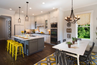 Inspiration for a large transitional l-shaped dark wood floor kitchen remodel in Atlanta with an undermount sink, recessed-panel cabinets, white cabinets, granite countertops, gray backsplash, mosaic tile backsplash, stainless steel appliances and an island