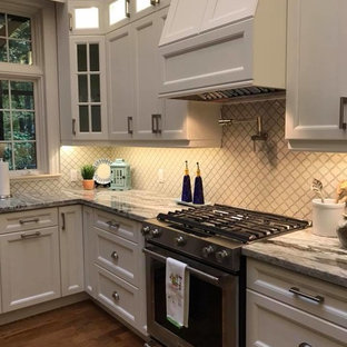 Exempel på ett stort klassiskt blå blått kök, med en rustik diskho, luckor med infälld panel, vita skåp, granitbänkskiva, vitt stänkskydd, stänkskydd i porslinskakel, rostfria vitvaror, mellanmörkt trägolv och en köksö