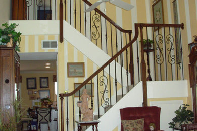 Foto de escalera en U minimalista de tamaño medio con escalones de madera, contrahuellas de madera pintada y barandilla de madera