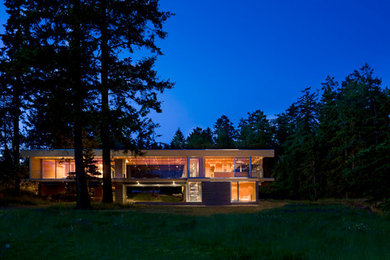 Example of a large minimalist beige two-story glass exterior home design in Vancouver