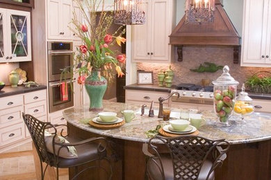 Example of a large country l-shaped ceramic tile and multicolored floor eat-in kitchen design in Atlanta with an undermount sink, shaker cabinets, light wood cabinets, granite countertops, beige backsplash, stone tile backsplash, stainless steel appliances and an island