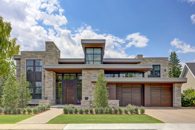 Example of a large minimalist beige two-story stone flat roof design in Calgary