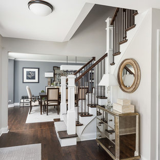 シカゴの大きい回転式ドアトランジショナルスタイルのおしゃれな玄関ロビー (グレーの壁、濃色無垢フローリング、濃色木目調のドア、茶色い床) の写真