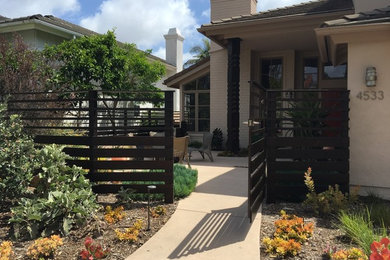 This is an example of a contemporary front yard full sun garden in San Diego with a garden path.