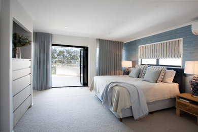 他の地域にある広いビーチスタイルのおしゃれな主寝室 (青い壁、カーペット敷き、ベージュの床、壁紙) のレイアウト