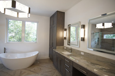 Large contemporary bathroom in Miami with shaker cabinets, dark wood cabinets, a freestanding bath, a one-piece toilet, porcelain flooring, granite worktops, beige floors, a sliding door, a single sink and a built in vanity unit.