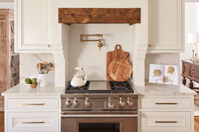 Inspiration for a dark wood floor and brown floor kitchen remodel in Other with white cabinets, marble countertops, white backsplash, brick backsplash, stainless steel appliances, an island and white countertops