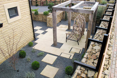 This is an example of a large contemporary back formal garden in Other with a retaining wall and decking.