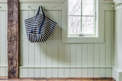 Mudroom - brick floor mudroom idea in Boston with green walls