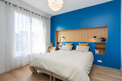 Inspiration pour une chambre parentale en bois de taille moyenne avec un mur bleu, parquet clair, aucune cheminée et un sol beige.