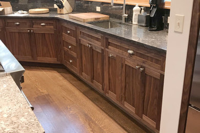Kitchen - craftsman medium tone wood floor and brown floor kitchen idea in Other with shaker cabinets, stainless steel countertops and an island
