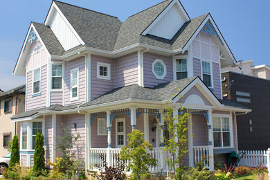 This is an example of a traditional two-storey pink exterior in Other with mixed siding and a gable roof.