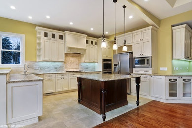Large elegant u-shaped travertine floor and beige floor open concept kitchen photo in Chicago with an undermount sink, recessed-panel cabinets, white cabinets, granite countertops, beige backsplash, travertine backsplash, stainless steel appliances and an island