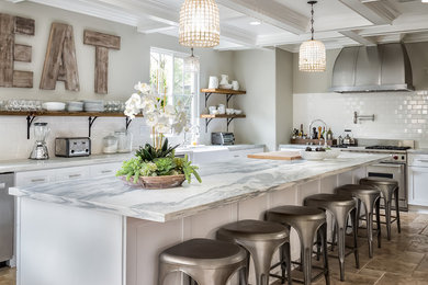Open concept kitchen - mediterranean u-shaped open concept kitchen idea in San Diego with marble countertops, white backsplash, ceramic backsplash, stainless steel appliances and an island