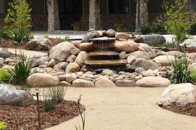 Photo of a large traditional drought-tolerant and partial sun front yard mulch water fountain landscape in Santa Barbara for summer.