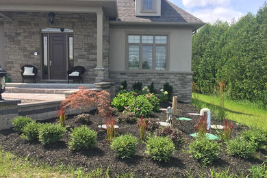 Photo of a huge traditional front yard brick landscaping in Toronto.