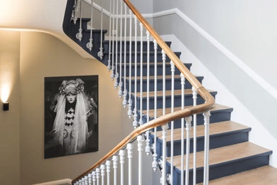 Cette photo montre un escalier peint chic de taille moyenne avec des marches en bois et un garde-corps en métal.