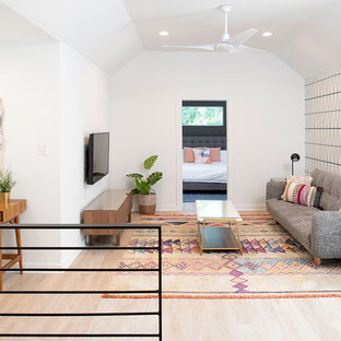 Mid-sized transitional loft-style light wood floor and brown floor family room photo in Austin with multicolored walls, no fireplace and no tv